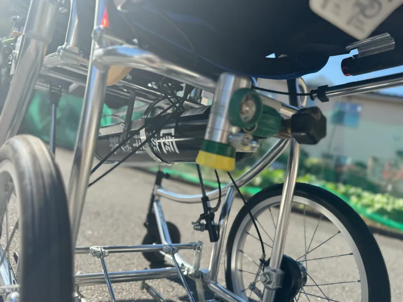 車椅子に取り付けた医療用酸素ボンベ